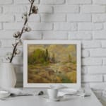 Vintage wall art of a rocky stream with green trees and a cloudy sky in warm earthy tones of brown, green, and yellow. displayed on the wall