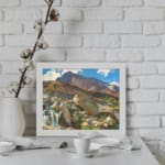 Vintage wall art of a mountain landscape with a waterfall, earthy rocks, green hills, and a blue sky with white clouds. displayed on the wall