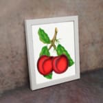 Vintage wall art featuring two red plums with green leaves on a white background. displayed on the wall
