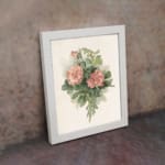 Infidu vintage pink floral wall art with two pink flowers and green leaves on a beige background in a white frame. displayed on the wall