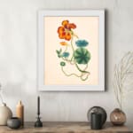 Vintage floral wall art with orange-red flower and green twisting vines on a beige background. displayed on the wall