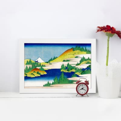 Infidu vintage wall art featuring a serene mountain lake with towering peaks, calm reflective waters, and surrounding trees. displayed on the wall art in a white frame