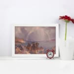 Vintage wall art of a calm lake with a rainbow, mountains, and soft sunlight. displayed on the wall