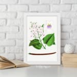 Vintage botanical wall art with soft pink and purple flowers and green leaves on a white background. displayed on the wall
