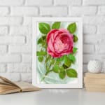 Infidu vintage wall art with a pink rose in full bloom and green leaves on a soft watercolor background. displayed on the wall