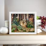 Vintage wall art of a brown rabbit sitting in a lush green forest with trees and plants in the background. displayed on the wall