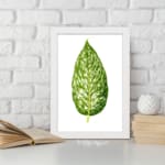 Vintage leaf wall art with a large green marbled leaf centered on a white background, framed in white, displayed on the wall