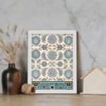 Vintage Persian floral and geometric wall art print with blue, teal, and purple flowers on a cream background in a white frame. displayed on the wall