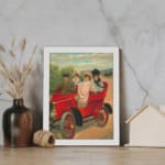 Vintage wall art of red antique car with four people in early 20th-century clothing, riding through the countryside. displayed on the wall in a white frame