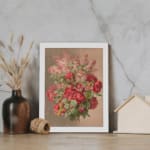 Vintage wall art of red roses and pink flowers with green leaves on a beige background, framed in white. displayed on the wall