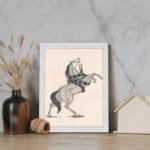 Black-and-white vintage sketch of a horse rearing with a snake wrapped around its body, framed in white. displayed on the wall