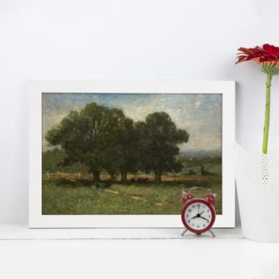 Vintage wall art of a serene pastoral landscape with trees, grassy fields, and a soft blue sky, ideal for rustic or nature-inspired decor. displayed on the wall in a white frame