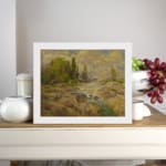 Vintage wall art of a rocky stream with green trees and a cloudy sky in warm earthy tones of brown, green, and yellow. displayed on the wall