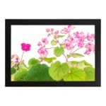 Infidu Vintage Floral Wall Art with pink flowers and green leaves on a white background, framed in black for a classic and elegant look. hung on the wall.