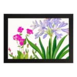 Infidu Vintage Floral Wall Art with soft purple and bright pink flowers, green leaves, a white background, and a black frame for a stylish touch. hung on the wall
