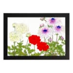 Vintage floral wall art with yellow, red, and purple flowers and green leaves on a white background. hung on the wall.
