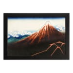 Vintage mountain landscape wall art with red, brown, and blue tones, featuring a striking reddish-brown mountain, blue sky, and black frame. hung on the wall
