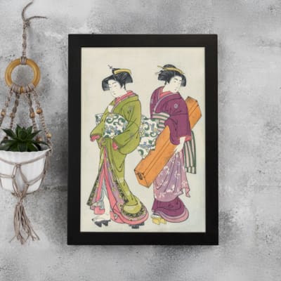 Vintage Japanese wall art with two women in kimonos, detailed patterns, and soft, rich colors. displayed on the wall in a black frame