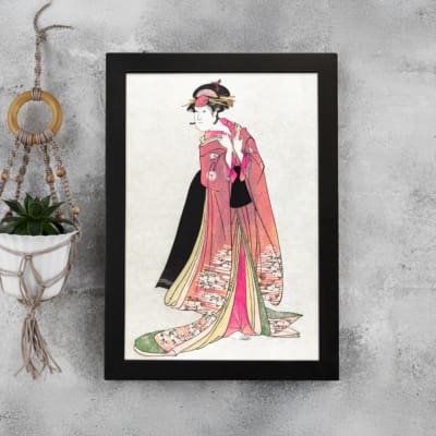 Vintage Japanese wall art of a woman in a floral kimono with intricate details, inspired by traditional woodblock prints. displayed on the wall in a black frame