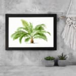 Vintage wall art with a detailed green palm plant in a black frame, featuring bright green leaves and a white background for a fresh, elegant look. displayed on the wall