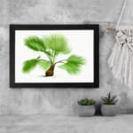 Vintage botanical wall art with a green palm plant, detailed leaves, and a brown base on a white background, framed in black for an elegant touch. displayed on the wall