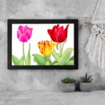 Infidu Vintage Floral Wall Art with pink, red, and yellow tulips, green leaves, and a black frame on a white background. displayed on the wall