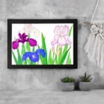 Vintage floral wall art with purple, blue, and pink flowers, green leaves, and a black frame on a white background. displayed on the wall