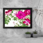 Infidu Vintage Floral Wall Art with pink and red flowers, green leaves, a white background, and a black frame for an elegant and timeless look. displayed on the wall
