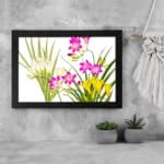 Infidu Vintage Floral Wall Art with pink, yellow & white flowers, green leaves, and a black frame on a white background. displayed on the wall