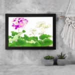 Infidu Vintage Floral Wall Art with pink, purple, and white flowers surrounded by green leaves on a white background, framed in black. displayed on the wall