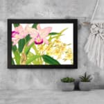 Vintage floral wall art with pink and yellow flowers, green leaves, and a black frame on a white background. displayed on the wall