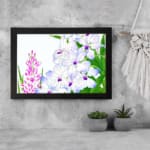Infidu Vintage Floral Wall Art with white, purple, and pink flowers, green leaves, and a black frame, adding a classic touch to any décor. displayed on the wall