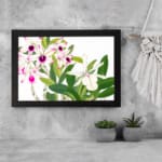 Vintage floral wall art with white and pink orchids, green leaves, and a black frame for an elegant and classic look. displayed on the wall