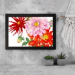 Vintage floral wall art with red, pink, and orange flowers, green leaves, and a black frame on a white background. displayed on the wall