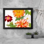 Vintage floral wall art with large orange, red, and white flowers, green leaves, and a black frame on a white background. displayed on the wall
