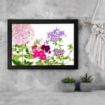 Infidu Vintage Floral Wall Art with soft pink, purple, and deep red flowers, green leaves, and a white background for a timeless, elegant look. displayed on the wall in a black frame