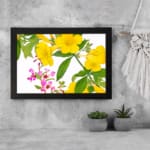 Infidu Vintage Floral Wall Art with yellow and pink flowers, green leaves, and a black frame on a white background. displayed on the wall
