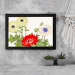 Vintage floral wall art with cream and red flowers, green leaves, and a white background in a classic design. displayed on the wall in a black frame