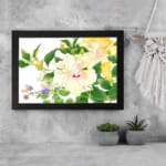 Infidu vintage wall art with soft yellow, white, and purple flowers, green leaves, and a black frame on a white background for a timeless botanical look. displayed on the wall