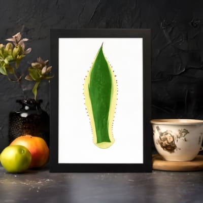 Minimalist green leaf design with yellow outline and dotted edges on white background, framed in black, vintage wall art. displayed on the wall in a black frame