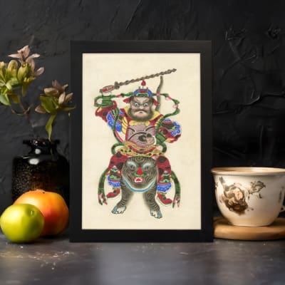 Infidu vintage wall art featuring a Chinese warrior in vibrant red, green, blue, and gold attire, standing atop a fierce mythical beast while wielding a staff, set against an off-white background. displayed on the wall art in a black frame