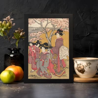 Japanese women in traditional kimonos standing under cherry blossom trees in a serene vintage-style outdoor setting. displayed on the wall in a black frame