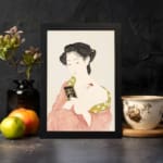 Vintage Japanese wall art featuring a woman in traditional dress holding a book with soft red and green patterns. displayed on the wall in a black frame