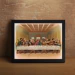Vintage wall art of the Last Supper with Jesus and his disciples in a detailed, warm-toned biblical setting. displayed on the wall in a black frame