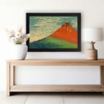 Infidu vintage wall art featuring an iconic view of Mount Fuji with a red-orange peak, a blue sky, and lush green surroundings in a traditional Japanese style. displayed on the wall art in a black frame