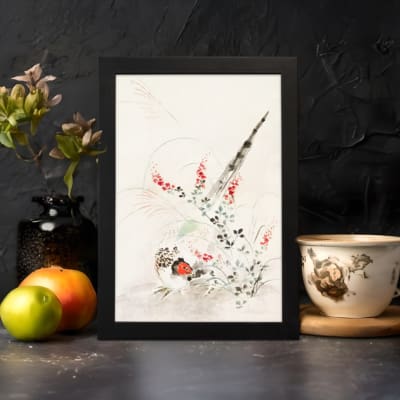 Vintage wall art with a bird surrounded by delicate flowers and plants in soft greens, reds, and whites, framed in black. displayed on the wall