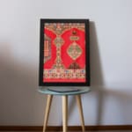 Vintage wall art with intricate red and gold patterns, floral and geometric designs, and a black frame for a timeless, decorative appeal. displayed on the wall