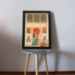 Vintage wall art with a Middle Eastern scene featuring a woman in a flowing outfit, ornate arches, and detailed architecture in warm and vibrant tones. displayed on the table