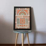 Infidu Vintage Wall Art with intricate geometric patterns in red, orange, beige, teal, and green, featuring symmetrical and decorative designs. displayed on the table in a black frame