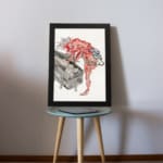 Vintage horror wall art of a red phantom with spiky hair over a black coffin, featuring a traditional Asian style with bold red, black, and white tones. displayed on the table